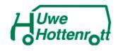 Uwe Hottenrott in grünem Umzugstransporter Logo